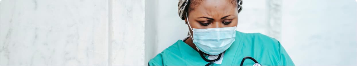 Clinical nurse with stethoscope and mask in a hospital corridor