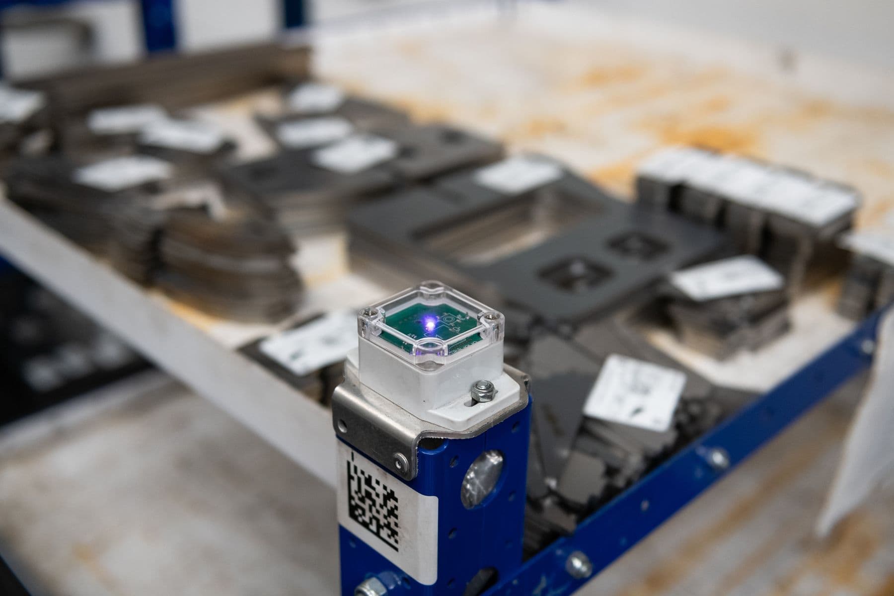 BLE asset-tracking tag mounted on a work-in-progress trolley on the factory floor